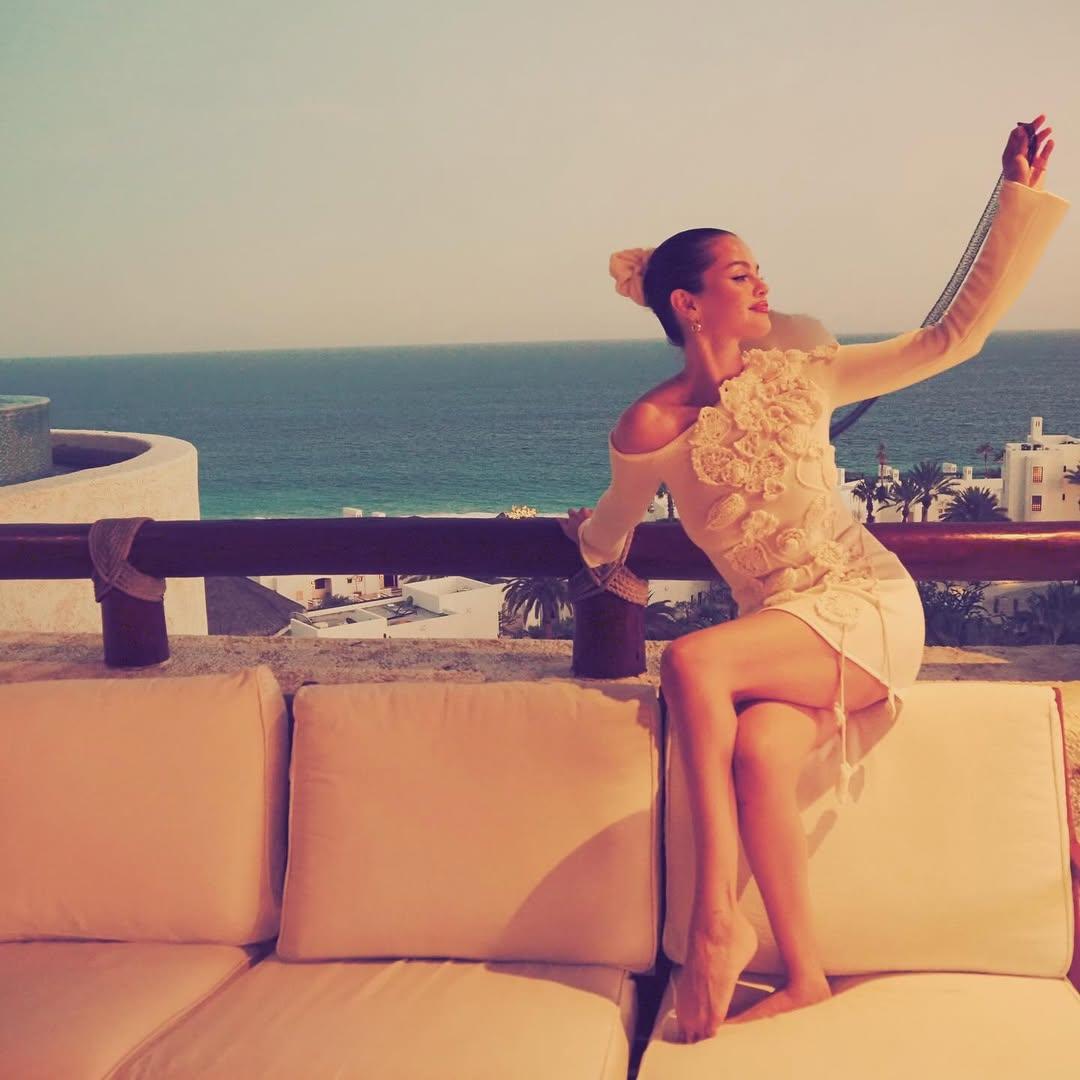 The photo dump began with an image of Selena enjoying a serene moment during her bachelorette party in Cabo. She is seen seated on a cream-coloured outdoor couch, with the ocean and a scenic coastal view in the background.